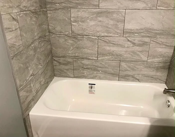 Tub with grey tiled surround at 2805 W Lake Shore Dr