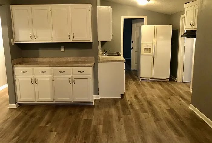 Kitchen with white cabinets and wood-look flooring at 2805 W Lake Shore Dr